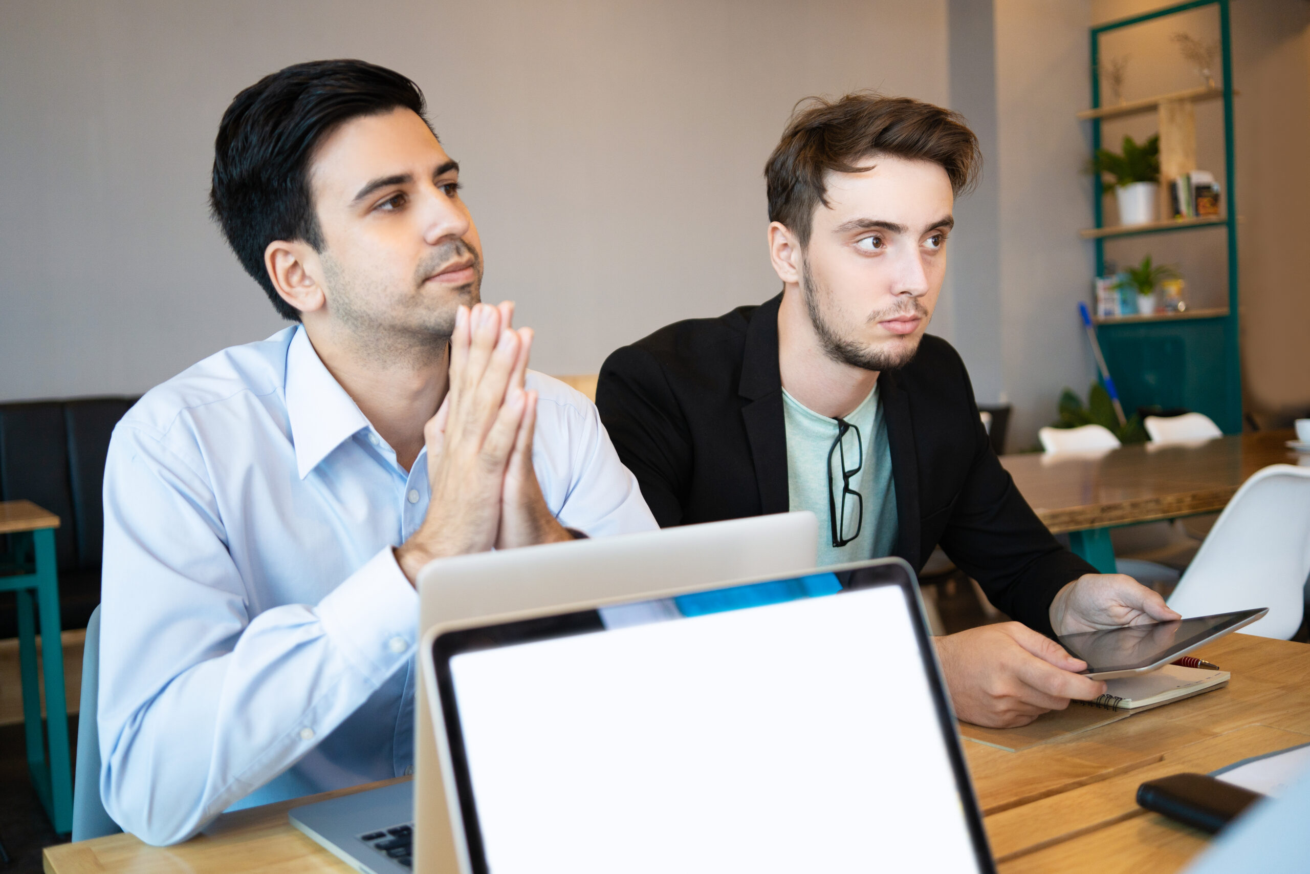 Two professionals listening to business conference speaker