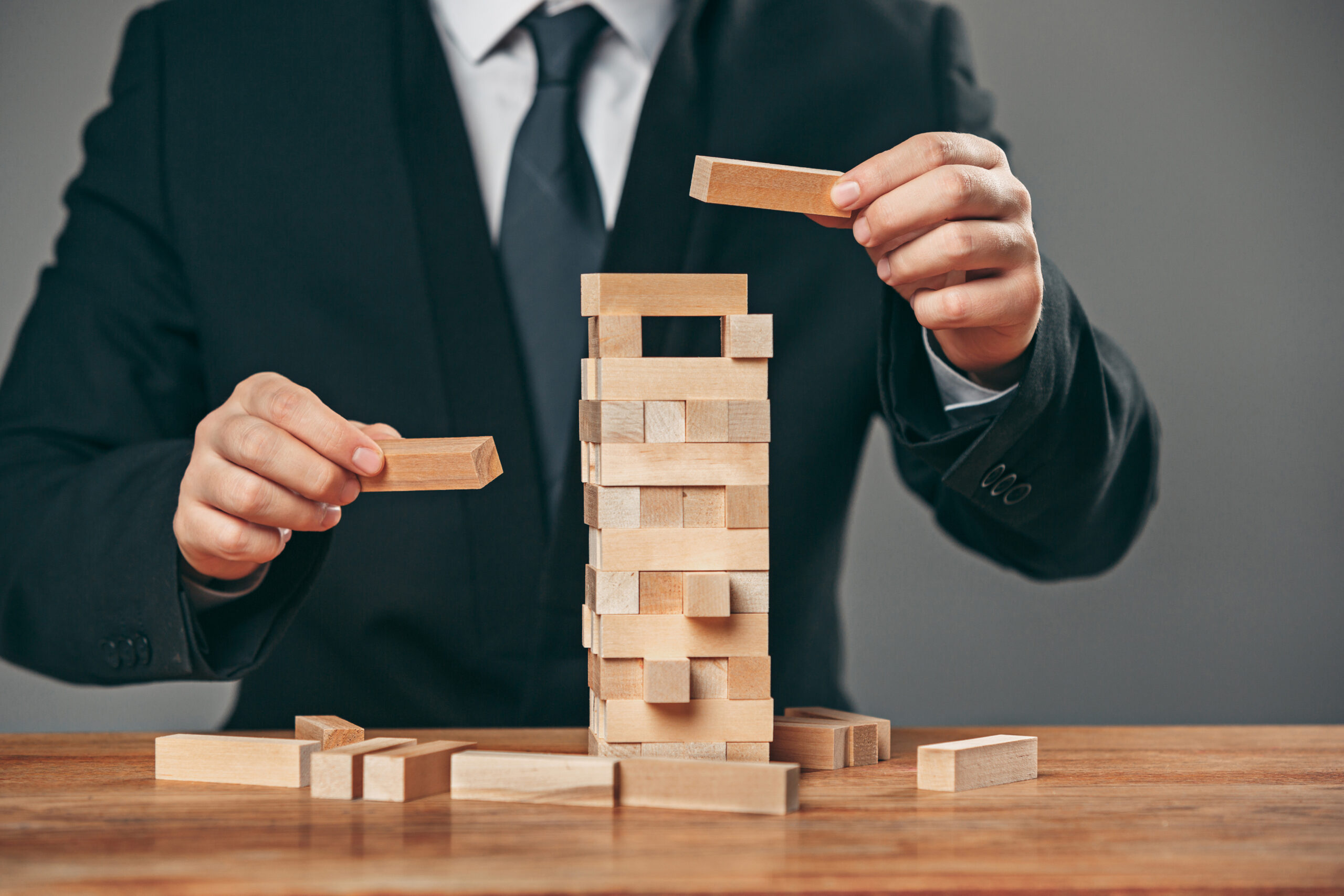 Man and wooden cubes on table. Management concept